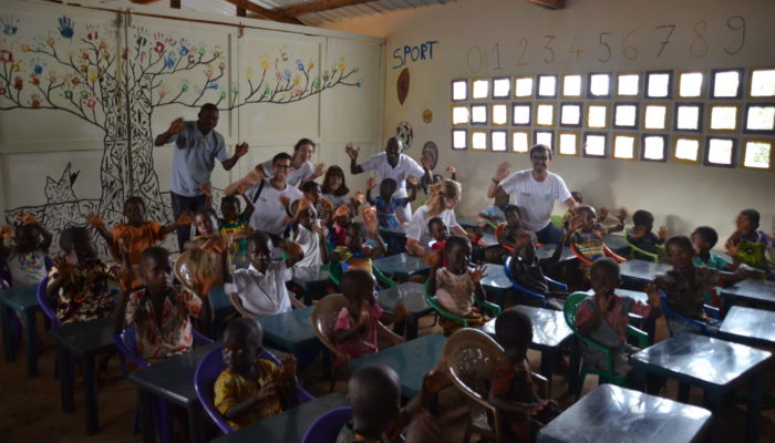 Enfants et bénévole de terre citoyenne et solidaire dans une école construite avec nos partenaires